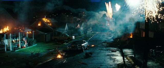 Wide shot frame from Super 8 — street, fire, night
