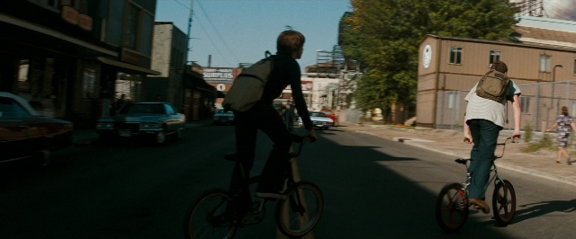 Wide shot frame from Super 8 — walking, street, car