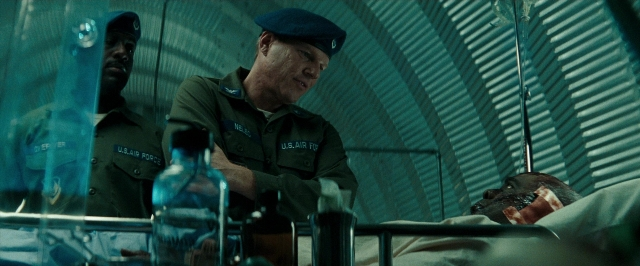 Wide shot frame from Super 8 — standing, room, table