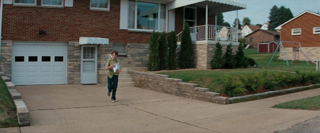 Wide shot frame from Super 8 — walking, door, street
