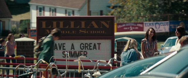 Wide shot frame from Super 8 — standing, walking, street