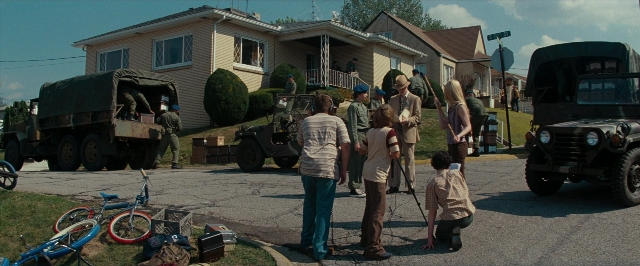 Wide shot frame from Super 8 — standing, street, bicycle