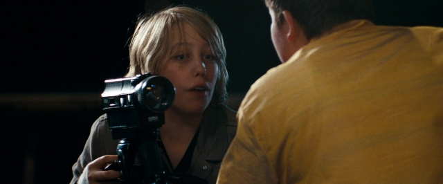 Medium shot frame from Super 8 — standing, night, shirt