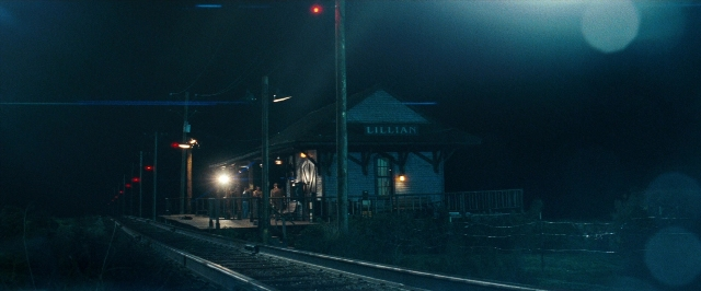 Wide shot frame from Super 8 — standing, night, train