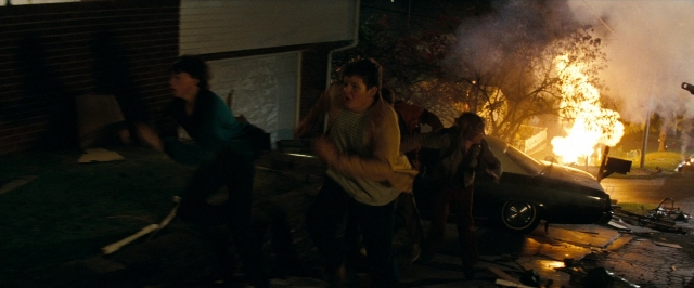 Wide shot frame from Super 8 — standing, fire, car