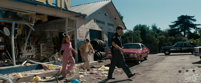 Wide shot frame from Super 8 — walking, street, hat