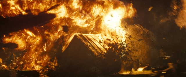 Wide shot frame from Super 8 — room, fire, poster
