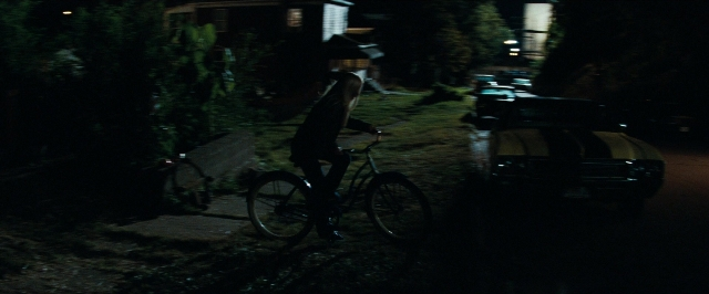 Wide shot frame from Super 8 — street, night, bicycle