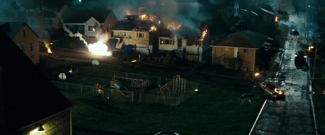 Wide shot frame from Super 8 — fire, night, house