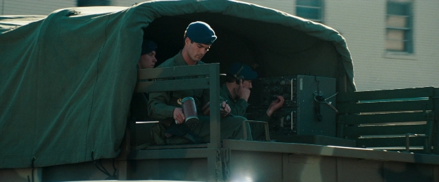 Wide shot frame from Super 8 — sitting, dialogue, car