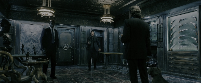 Wide shot frame from John Wick: Chapter 3 - Parabellum — standing, room, table