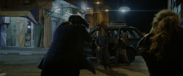 Wide shot frame from John Wick: Chapter 3 - Parabellum — walking, street, car
