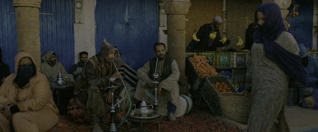 Wide shot frame from John Wick: Chapter 3 - Parabellum — sitting, standing, cigarette