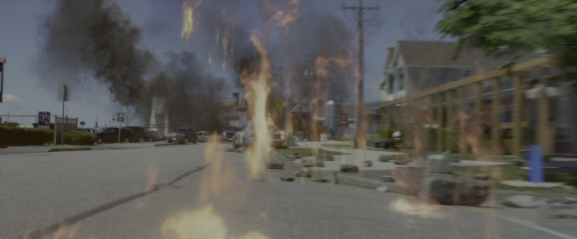Wide shot frame from Power Rangers — street, fire, smoke
