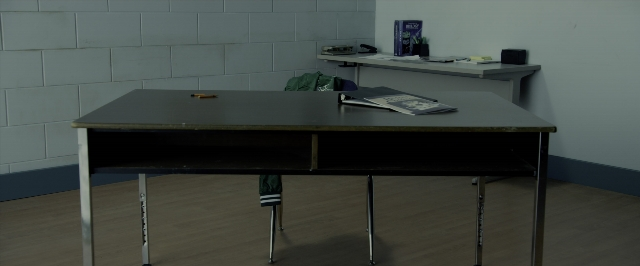 Wide shot frame from Power Rangers — desk, book, room
