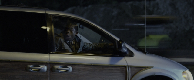 Wide shot frame from Power Rangers — sitting, door, street