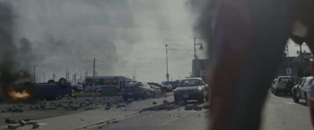 Wide shot frame from Power Rangers — street, fire, car