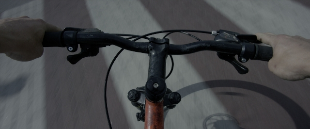 Wide shot frame from Power Rangers — bicycle, human hand, running