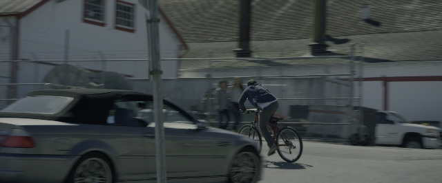 Wide shot frame from Power Rangers — street, car, bicycle