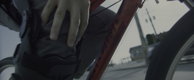 Wide shot frame from Power Rangers — street, hand, bicycle