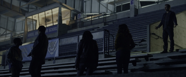 Wide shot frame from Power Rangers — standing, banner, person