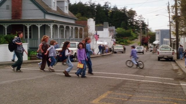 Wide shot frame from Practical Magic — walking, street, house