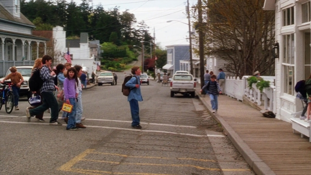 Wide shot frame from Practical Magic — walking, street, bicycle