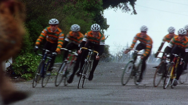 Wide shot frame from Practical Magic — street, bicycle, person