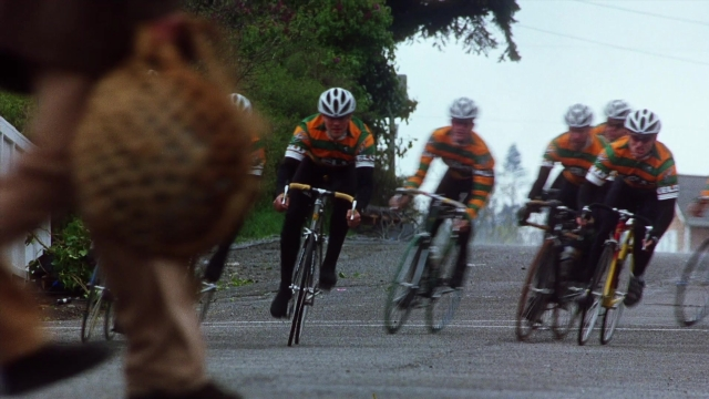 Wide shot frame from Practical Magic — street, bicycle, person