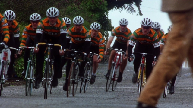 Wide shot frame from Practical Magic — street, bicycle, person