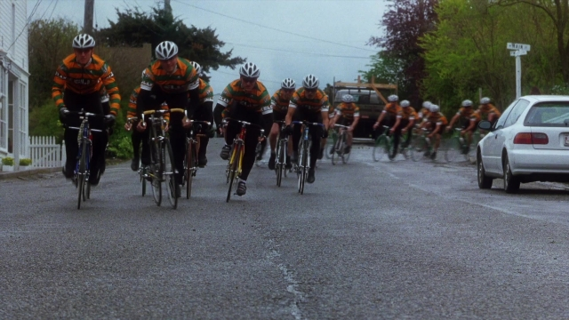 Wide shot frame from Practical Magic — street, car, bicycle