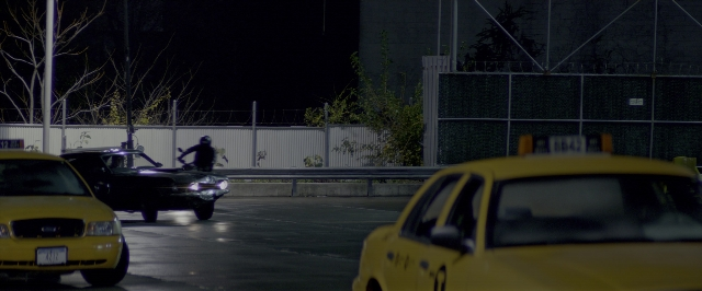 Wide shot frame from John Wick: Chapter Two — hat, car, night