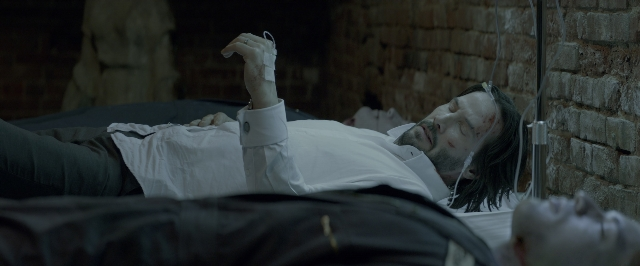 Wide shot frame from John Wick: Chapter Two — bed, hand, shirt