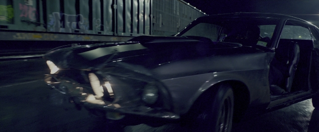 Wide shot frame from John Wick: Chapter Two — street, car, train
