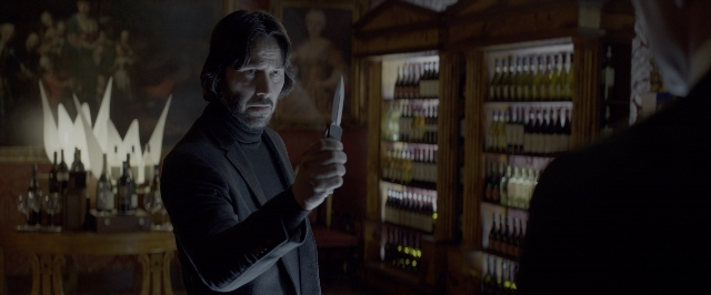 Wide shot frame from John Wick: Chapter Two — standing, room, table