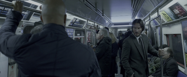 Wide shot frame from John Wick: Chapter Two — sitting, standing, dialogue