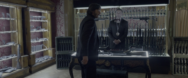 Wide shot frame from John Wick: Chapter Two — standing, room, table