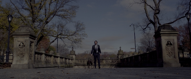 Wide shot frame from John Wick: Chapter Two — walking, dog, suit