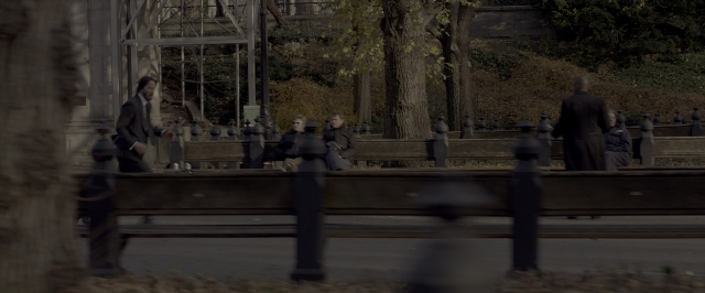 Wide shot frame from John Wick: Chapter Two — sitting, book, dialogue