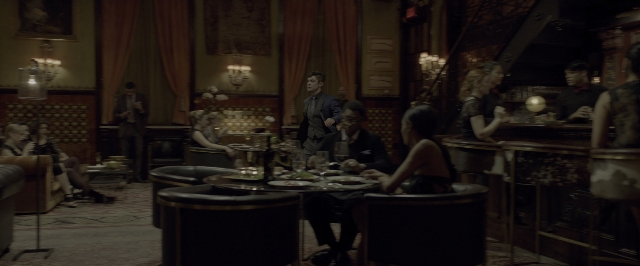 Wide shot frame from John Wick: Chapter Two — sitting, standing, room