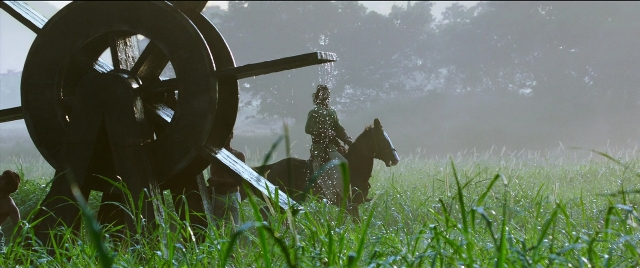 Wide shot frame from Bãhubali 2: The Conclusion — standing, hat, horse