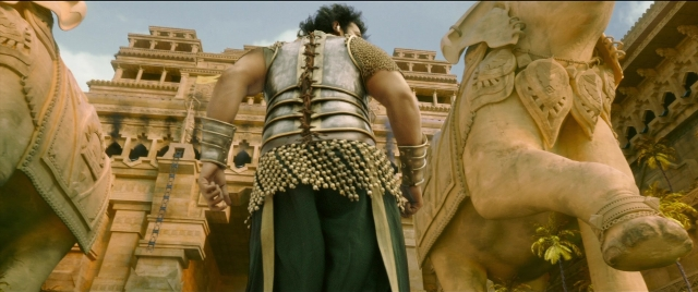 Wide shot frame from Bãhubali 2: The Conclusion — standing, suit, hair
