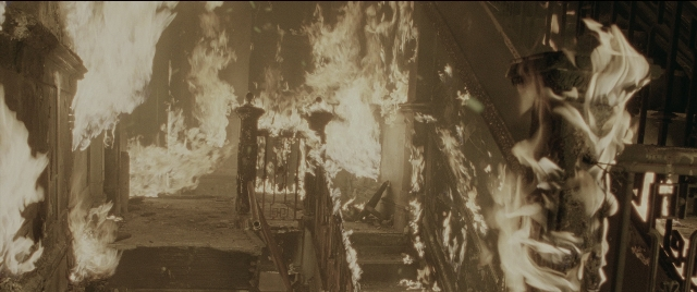 Wide shot frame from Spider-Man 2 — fire, smoke, building