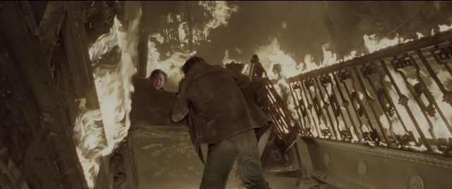 Wide shot frame from Spider-Man 2 — standing, fire, gun