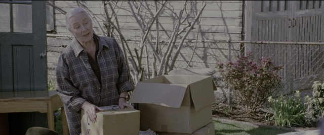 Wide shot frame from Spider-Man 2 — standing, table, door