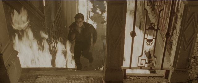Wide shot frame from Spider-Man 2 — walking, fire, face