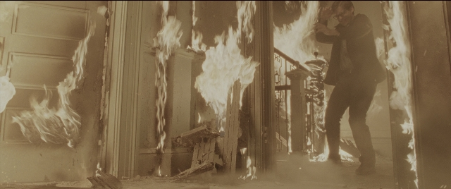 Wide shot frame from Spider-Man 2 — standing, fire, hand