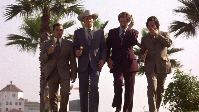 Wide shot frame from Anchorman: The Legend of Ron Burgundy — walking, street, hat