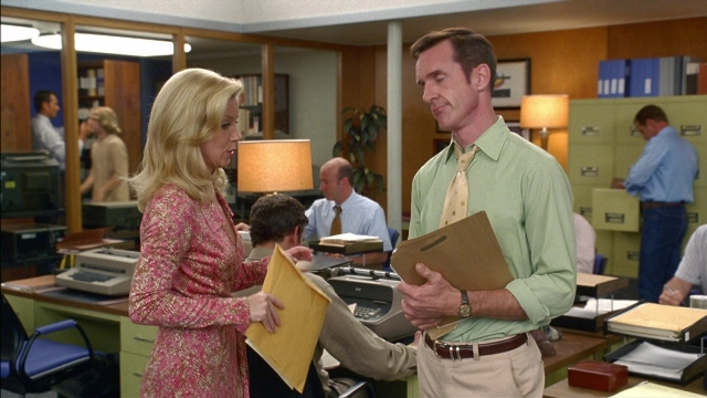 Wide shot frame from Anchorman: The Legend of Ron Burgundy — standing, hand, tie