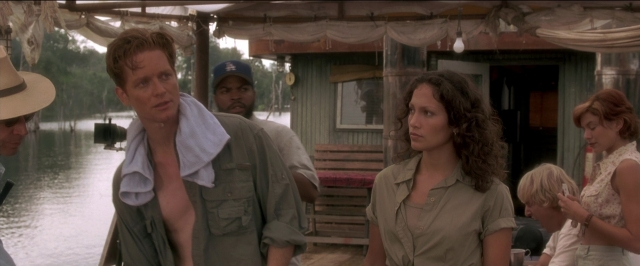 Wide shot frame from Anaconda — plate, table, dialogue